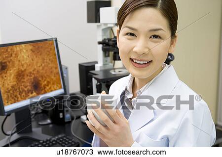 Portrait of a female scientist holding a coffee cup in laboratory, smiling and looking at camera, front view View Large Photo Image Stock Image - Portrait of a female scientist holding a coffee cup in laboratory, smiling and looking at camera, front view. Fotosearch