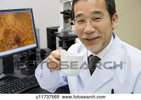 Portrait of a male scientist holding a coffee cup in laboratory, smiling and looking at camera, front view View Large Photo Image Stock Photo - Portrait of a male scientist holding a coffee cup in laboratory, smiling and looking at camera, front view. Fotosearch
