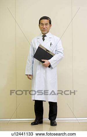 Stock Image - Portrait of a male scientist, smiling and looking at camera, front view. Fotosearch