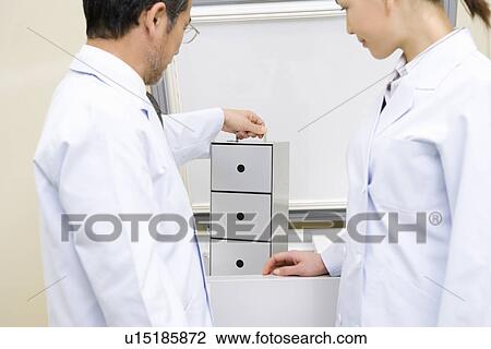 Two scientists in laboratory, man holding case, side view View Large Photo Image Stock Image - Two scientists in laboratory, man holding case, side view. Fotosearch