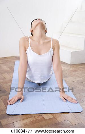 Stock Photo - Young woman doing yoga exercise, stretching, front view . Fotosearch