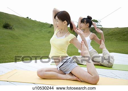 Picture - Young women doing yoga exercise, stretching, side view . Fotosearch