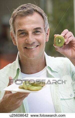 A man eating kiwi fruit View Large Photo Image Stock Image - A man eating kiwi fruit. Fotosearch