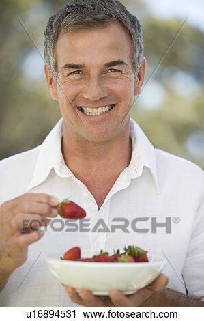 A man holding a bowl of strawberries View Large Photo Image Stock Image - A man holding a bowl of strawberries. Fotosearch