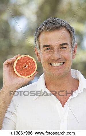 A man holding a grapefruit View Large Photo Image Stock Photograph - A man holding a grapefruit. Fotosearch