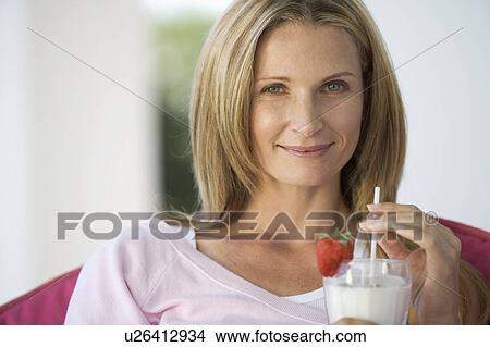 Picture - A woman drinking a health drink. Fotosearch