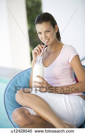 A woman drinking milk through a straw View Large Photo Image Stock Image - A woman drinking milk through a straw. Fotosearch