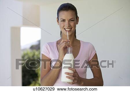 A woman drinking milk through a straw View Large Photo Image Stock Photo - A woman drinking milk through a straw. Fotosearch