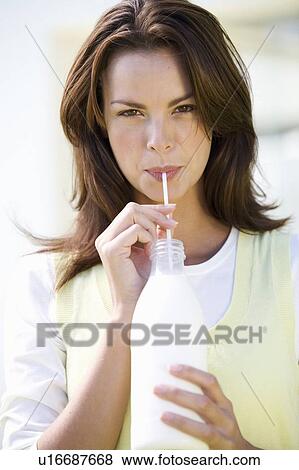 Stock Photo - A woman drinking milk through a straw. Fotosearch