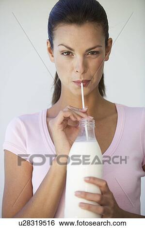 A woman drinking milk through a straw View Large Photo Image Stock Photograph - A woman drinking milk through a straw. Fotosearch