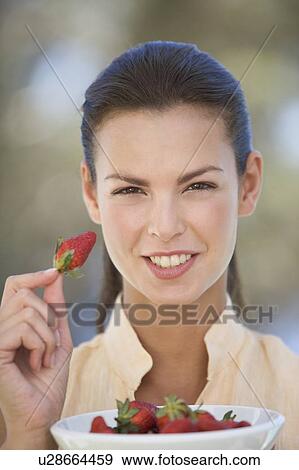 A woman eating a bowl of strawberries View Large Photo Image Stock Photo - A woman eating a bowl of strawberries. Fotosearch