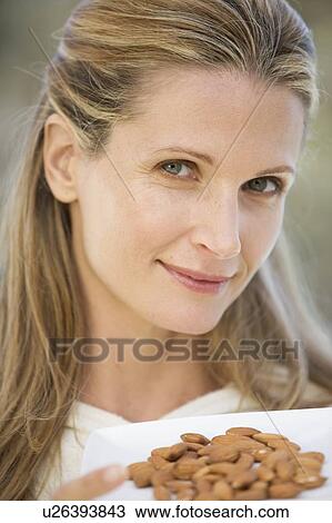 A woman holding a dish of almonds View Large Photo Image Stock Image - A woman holding a dish of almonds. Fotosearch