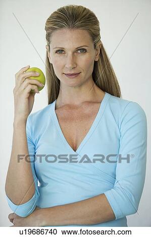 Stock Image - A woman holding an apple. Fotosearch