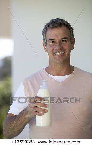 Man holding a bottle of milk View Large Photo Image Stock Image - Man holding a bottle of milk. Fotosearch