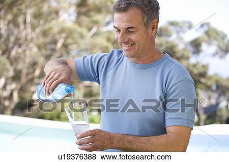 Stock Photo - Man pouring a glass of water. Fotosearch