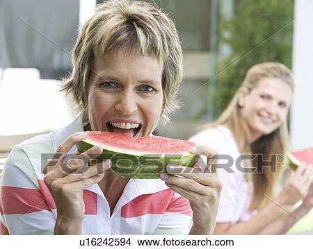 Two women eating watermelon View Large Photo Image Picture - Two women eating watermelon. Fotosearch