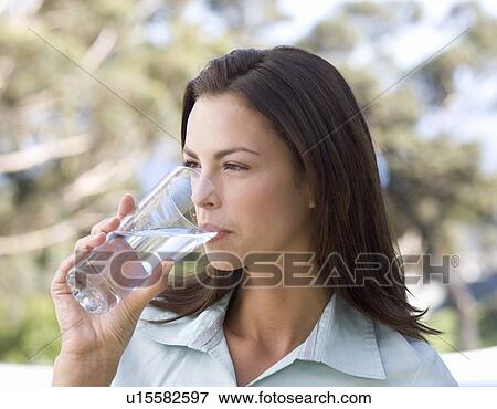 Woman drinking a glass of water View Large Photo Image Stock Photo - Woman drinking a glass of water. Fotosearch