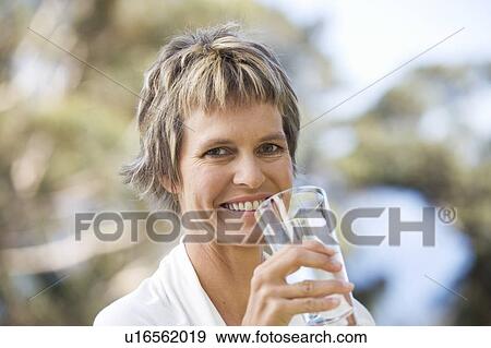 Woman drinking a glass of water View Large Photo Image Stock Photo - Woman drinking a glass of water. Fotosearch