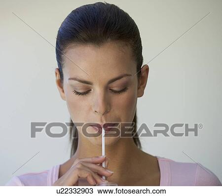 Woman drinking through a straw View Large Photo Image Stock Image - Woman drinking through a straw. Fotosearch