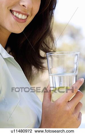 Woman holding a glass of water, close-up View Large Photo Image Stock Image - Woman holding a glass of water, close-up. Fotosearch