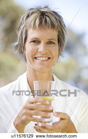 Stock Photo - Woman holding a glass of water. Fotosearch