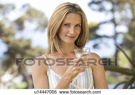 Woman holding a glass of water View Large Photo Image Stock Photography - Woman holding a glass of water. Fotosearch