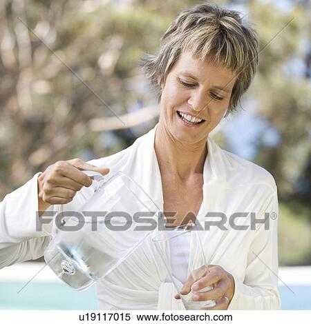 Stock Photography - Woman pouring a glass of water. Fotosearch
