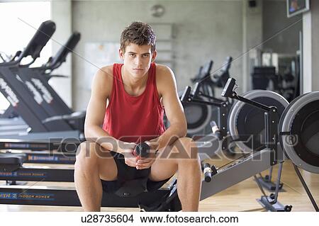 Picture - A young man at a gym. Fotosearch