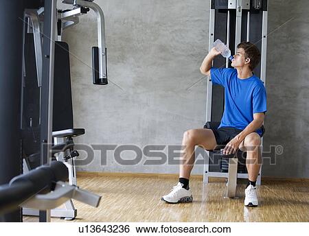 A young man drinking a bottle of water View Large Photo Image Stock Photograph - A young man drinking a bottle of water. Fotosearch
