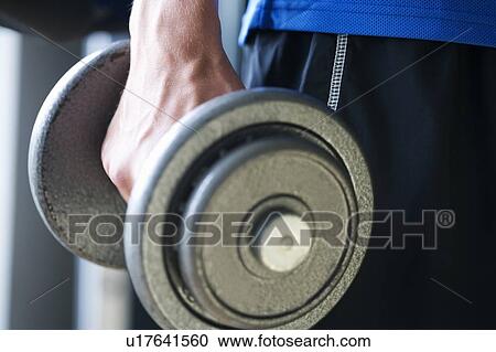 A young man lifting weights, close-up View Large Photo Image Stock Image - A young man lifting weights, close-up. Fotosearch