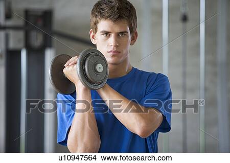 A young man lifting weights View Large Photo Image Picture - A young man lifting weights. Fotosearch