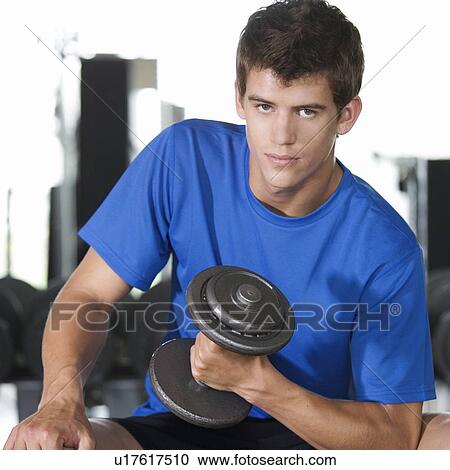 A young man lifting weights View Large Photo Image Stock Image - A young man lifting weights. Fotosearch