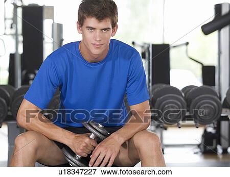 A young man lifting weights View Large Photo Image Stock Photo - A young man lifting weights. Fotosearch