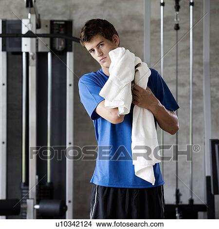 A young man standing in a gym View Large Photo Image Picture - A young man standing in a gym. Fotosearch