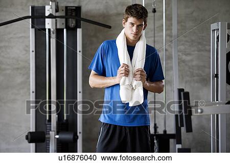 A young man standing in a gym View Large Photo Image Stock Image - A young man standing in a gym. Fotosearch
