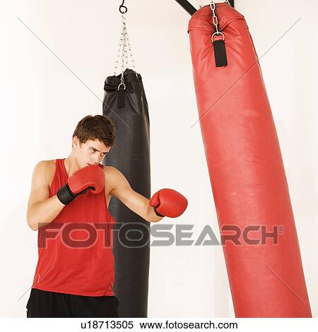 Stock Photography - A young man training on a punch bag. Fotosearch