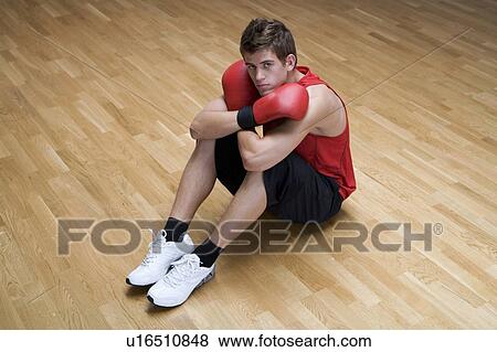 Stock Photo - A young man wearing boxing gloves. Fotosearch
