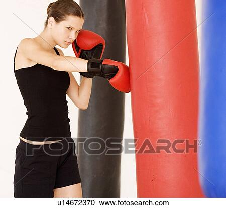 Stock Image - A young woman boxing. Fotosearch