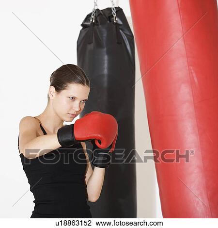 Stock Image - A young woman boxing. Fotosearch