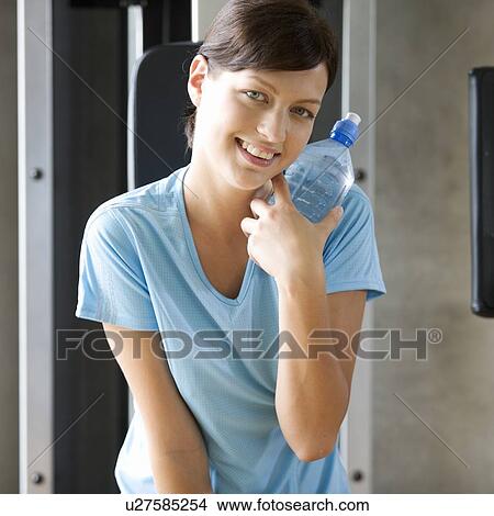 Picture - A young woman holding a bottle of water. Fotosearch