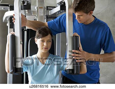 Stock Photograph - A young woman with a personal trainer. Fotosearch