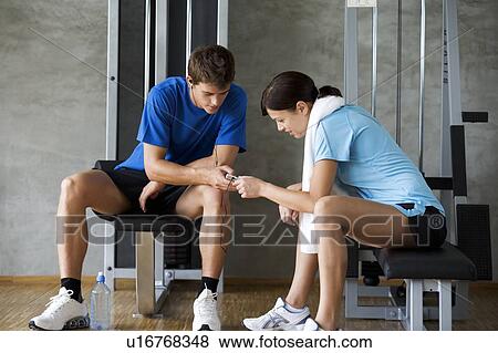 Two friends listening to music in a gym View Large Photo Image Stock Photo - Two friends listening to music in a gym. Fotosearch