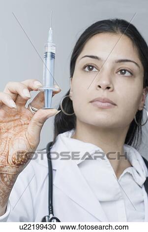 Close-up of a female doctor holding a syringe View Large Photo Image Stock Image - Close-up of a female doctor holding a syringe. Fotosearch