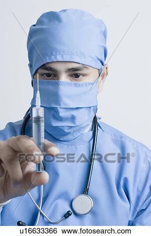 Stock Photograph - Close-up of a surgeon holding a syringe. Fotosearch