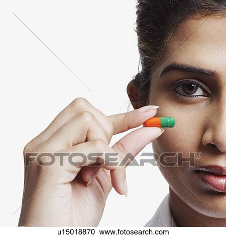 Portrait of a businesswoman holding a capsule View Large Photo Image Stock Image - Portrait of a businesswoman holding a capsule. Fotosearch