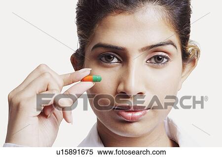 Portrait of a businesswoman holding a capsule View Large Photo Image Stock Photography - Portrait of a businesswoman holding a capsule. Fotosearch
