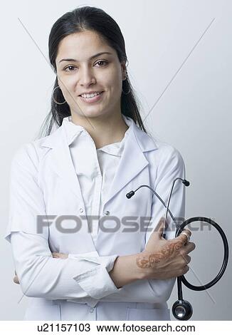 Portrait of a female doctor holding a stethoscope and smiling View Large Photo Image Stock Image - Portrait of a female doctor holding a stethoscope and smiling. Fotosearch