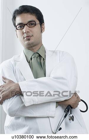 Portrait of a male doctor holding a stethoscope View Large Photo Image Stock Image - Portrait of a male doctor holding a stethoscope. Fotosearch
