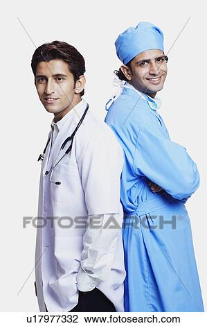 Stock Image - Portrait of two male doctors standing back to back. Fotosearch