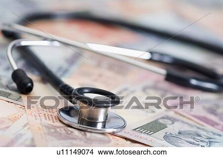 Stethoscope on Indian banknotes of different denominations View Large Photo Image Picture - Stethoscope on Indian banknotes of different denominations. Fotosearch